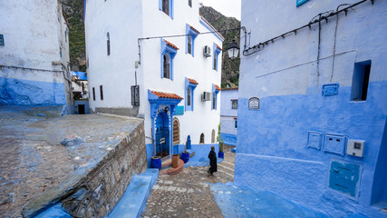 Unidentified man walking in blue medina of Chefchaouen city in Morocco, North Africa