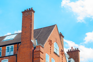 Red brick building with chimney against a blue bright sky