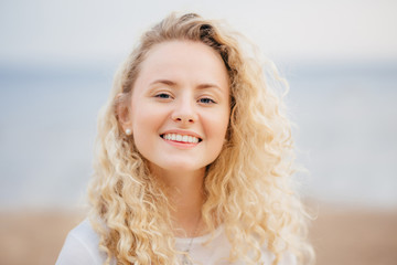 Headshot of beautiful woman with friendly smile, has healthy skin, being in good mood after...