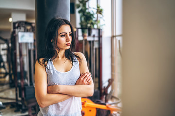 Sporty girl near punching bag in the gym