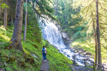 Obraz premium Adventurous girl discovering a huge waterfall in the woods