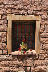 Window with stone wall and pot with flowers