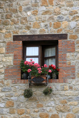 Fototapeta na wymiar Window with stone wall and pot with flowers