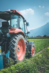 Fototapeta premium Traktor auf Acker, Landwirtschaft, blauer Himmel