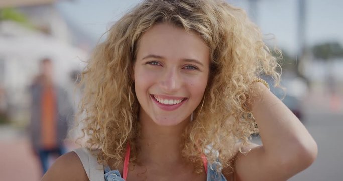 portrait of attractive blonde woman tourist running hand through hair smiling confident enjoying relaxed sunny day on summer vacation