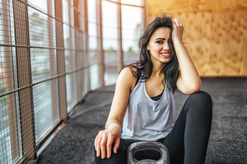 Cute sporty girl sitting in the gym