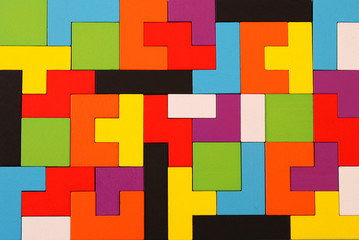 A colorful square tangram puzzle, over wooden table.