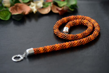 Bead crochet necklace amber color on a dark background close up
