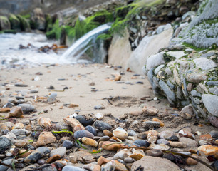 small waterfall leading on to pebble beach