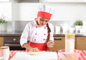 Pretty little girl baking in the kitchen at home