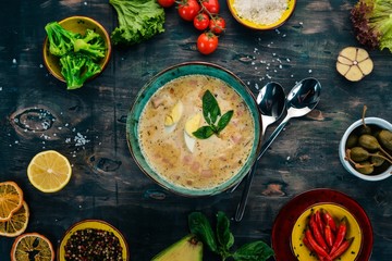 Creamy soup with bacon, chicken egg, vegetables and basil. On a wooden table. Top view. Copy space.