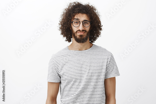 Studio Shot Of Unsure Good Looking Bearded Male With Curly