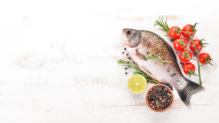 Raw Fish with Spices and Vegetables. Carp On a wooden background. Top view. Copy space.