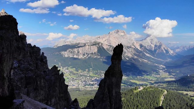 Aerial Scenic view of Cortina d' Ampezzo surrounded by majestic mountains . Dolomites Mountains. Rocky mountains in the shadow. Italian Dolomites valley. Drone Footage over the mountain peak