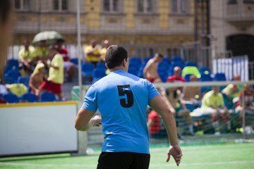 Football player on the football field with a blue T-shirt. Player number five. Soccer game