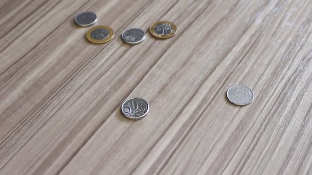 Moedas em real do Brasil caindo na mesa