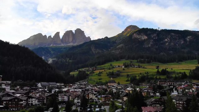 Aerial view from drone Campitello Di Fasa, Dolomites, Italy. Rocky mountains in the background. Italian Dolomites Mountains Village.  Canazei