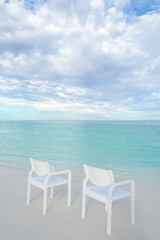 Fototapeta na wymiar Summer concept , White chair on the beach white sand and turquoise sea color at maldives on the weekend holidays