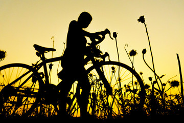 Obraz premium Silhouette of cyclist with friend in motion on the background of beautiful sunset