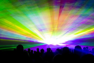 Rainbow laser show. Very colorful show with a crowd silhouette and great laser rays at youth party festival - 215520389