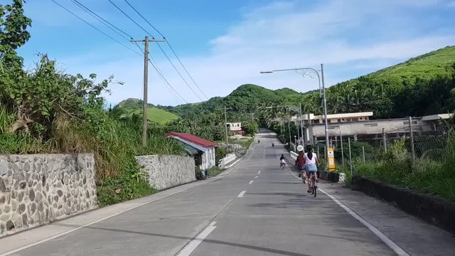 A family cycling downhill in the roads of Basco, Batanes in Philippines.