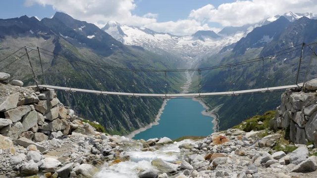 Rope Bridge near Olpererh&uuml;tte with Schlegeisspeicher Water Reservoir and Power Station at Zillertal Tirol Austria 4K