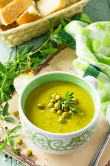 Diet menu. Puree soup with green pea in a bowl on a kitchen wooden table. The concept of healthy eating.