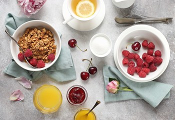 Breakfast table setting with granola and fresh raspberries. Overhead view