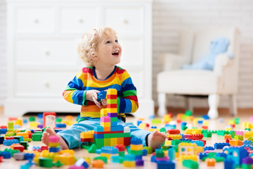 Child playing with toy blocks. Toys for kids.