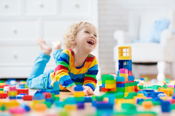 Child playing with toy blocks. Toys for kids.