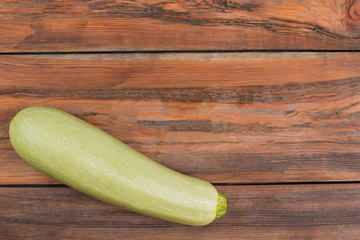 Raw fresh courgette on wood. Top view. Copyspace.
