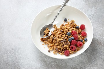 Granola. Healthy breakfast with granola and seasonal berries. Gray concrete background