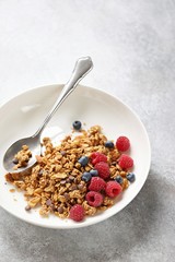 Granola. Healthy breakfast with granola and seasonal berries. Gray concrete background