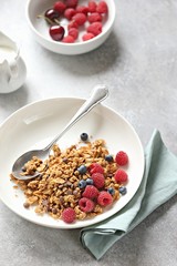 Granola. Healthy breakfast with granola and seasonal berries. Gray concrete background
