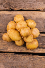 Pile of potatoes top view. Wooden desk background.