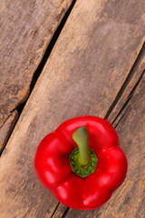 Red bell pepper on wood. Top view. Fresh red bell pepper on wooden desk surface.