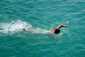 girl swims freestyle in the sea