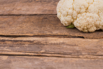 White cauliflower and copyspace. Old rustic wooden table.