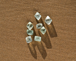 Fototapeta na wymiar Green Fluorite Natural Octahedron Crystals on the beach at sunrise.