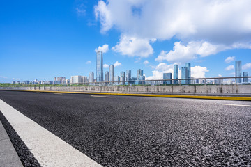 Fototapeta na wymiar asphalt road with city skyline