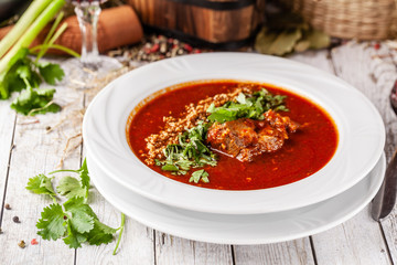 Traditional Georgian and Armenian cuisine. Tomato soup with rice Harcho of lamb, with walnut, garlic and cilantro. Copy space, selective focus