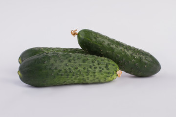 Heap of fresh cucumbers isolated over white background. Close up. Three ripe fresh cucumbers.