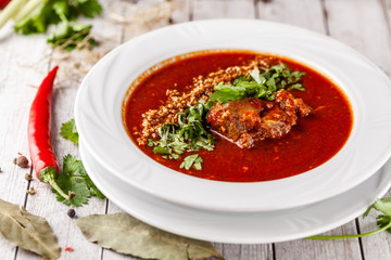 Traditional Georgian and Armenian cuisine. Tomato soup with rice Harcho of lamb, with walnut, garlic and cilantro. Copy space, selective focus