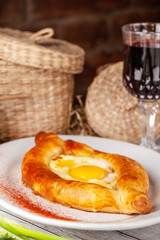 Traditional Georgian and Armenian cuisine. Khachapuri with suluguni cheese and egg yolk. background image. Copy space, selective focus