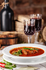 Traditional Georgian and Armenian cuisine. Tomato soup with rice Harcho of lamb, with walnut, garlic and cilantro. Copy space, selective focus