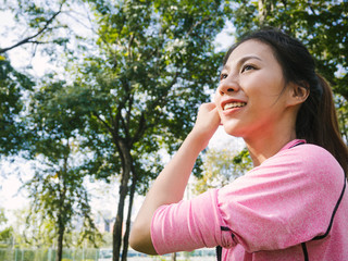Fototapeta premium Asian young woman warm up the body stretching before morning exercise and yoga in the park under warm light morning. Healthy young asian woman exercising at park. Woman exercise outdoor concept.