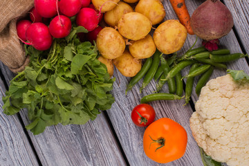 Set of fresh vegetables on wood. Top view. Parsley, radish, potato, peas, tomatoes, cauliflower and beetroot.