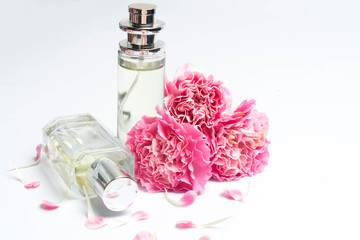 Perfume bottles and pink carnations on white background