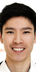 Portrait of young attractive asian creative man smiling and looking at camera in modern office feeling confident and positive. Headshot of chinese male employee, entrepreneur or college student.
