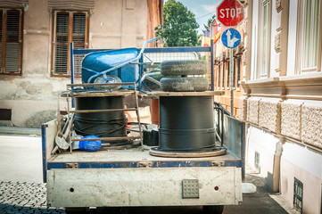 Cargo truck full of tools and underground optic cables roll for internet parked on the street for reconstruction work